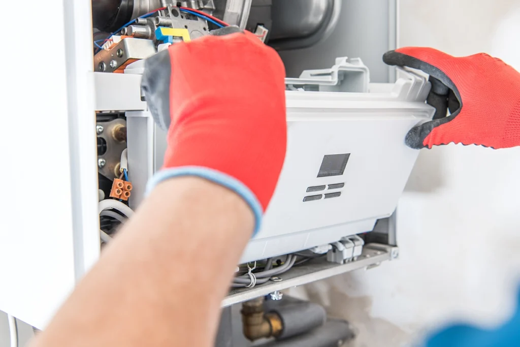 Furnace blower motor making rattling noise during heating in Thibodaux, LA: technician removing the front cover