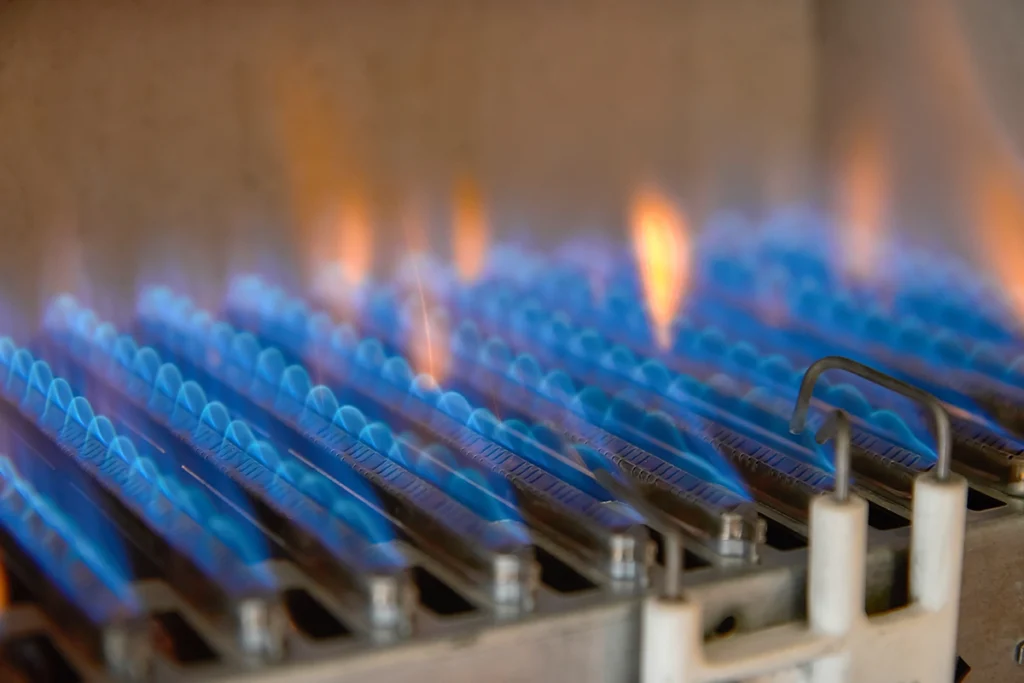 Furnace blower motor making squealing noise during heating cycle in Labadieville LA: close-up of blue burner flames