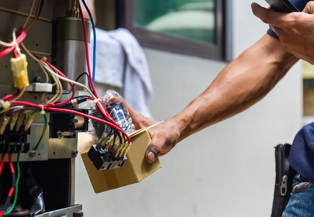 HVAC technician working on electrical components and wiring inside heating or cooling equipment. Suitable for blogs about HVAC electrical problems, capacitors, contactors, control components, system troubleshooting, AC repair, and HVAC maintenance.