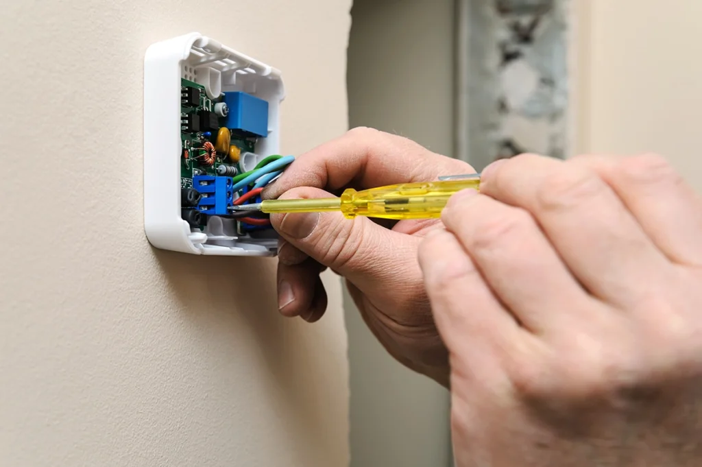 Thermostat not communicating with furnace control board in Raceland, LA: technician working on an open wall-mounted
